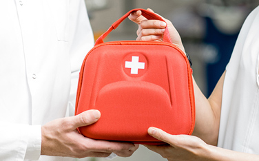 Pharmacist with client and first aid kit in the pharmacy