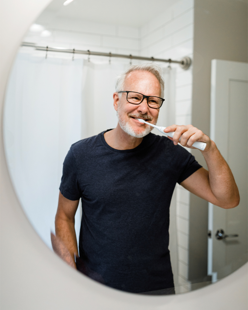 older-man-brushing-teeth-in-mirror-800x1000.jpg