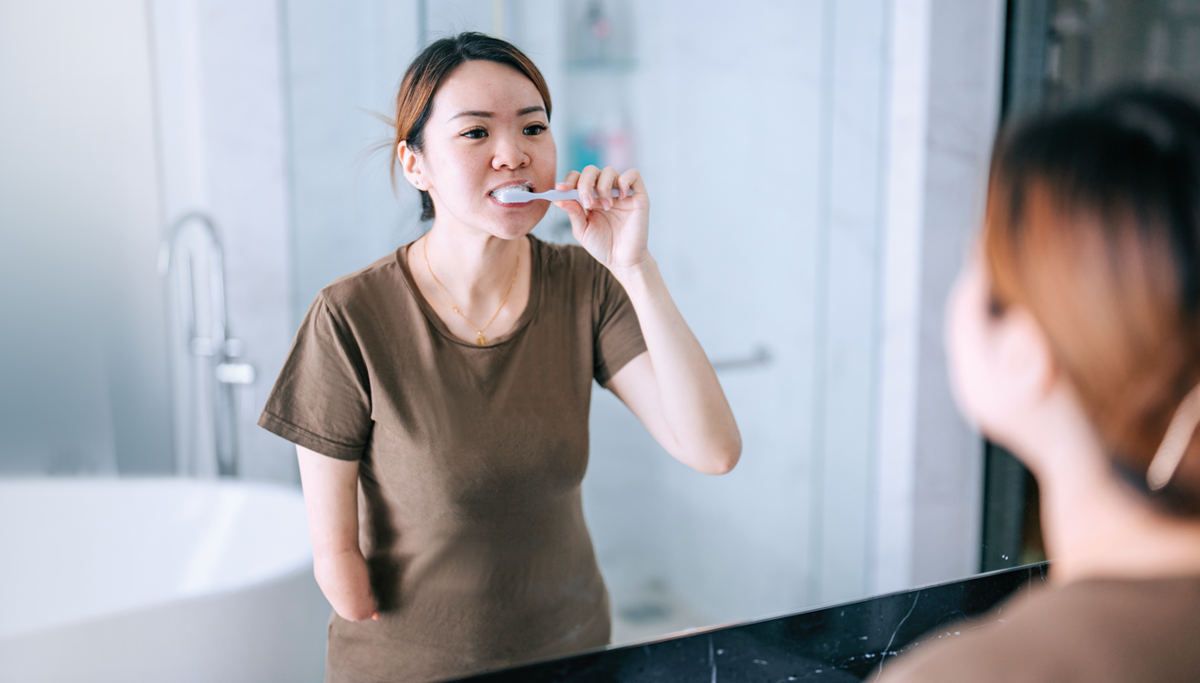 woman-brushing-teeth-in-mirror-1200x683.png