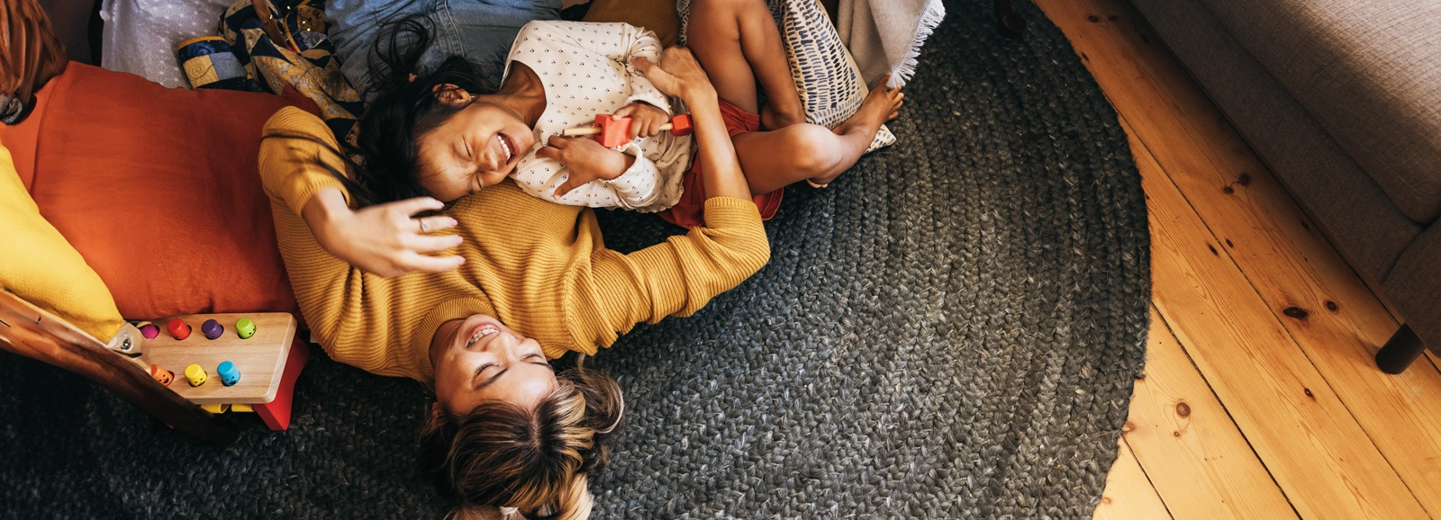 mom-and-daughter-laughing-on-the-floor-1600x578.webp